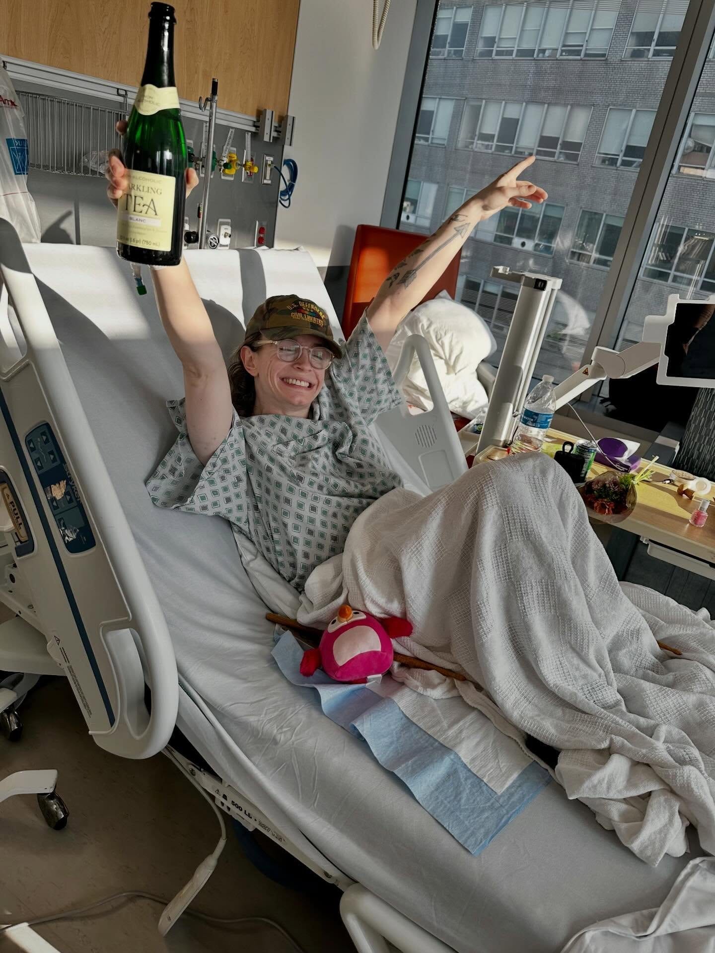 Grace celebrating in her hospital bed with a view of the city.