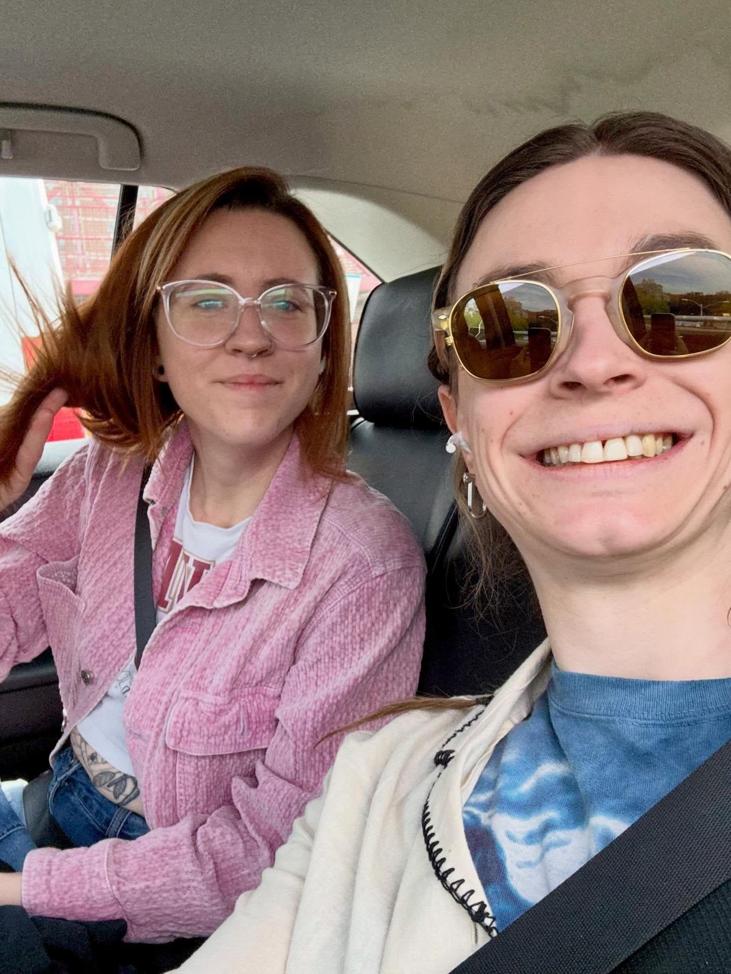 Grace smiling with a friend in a car.