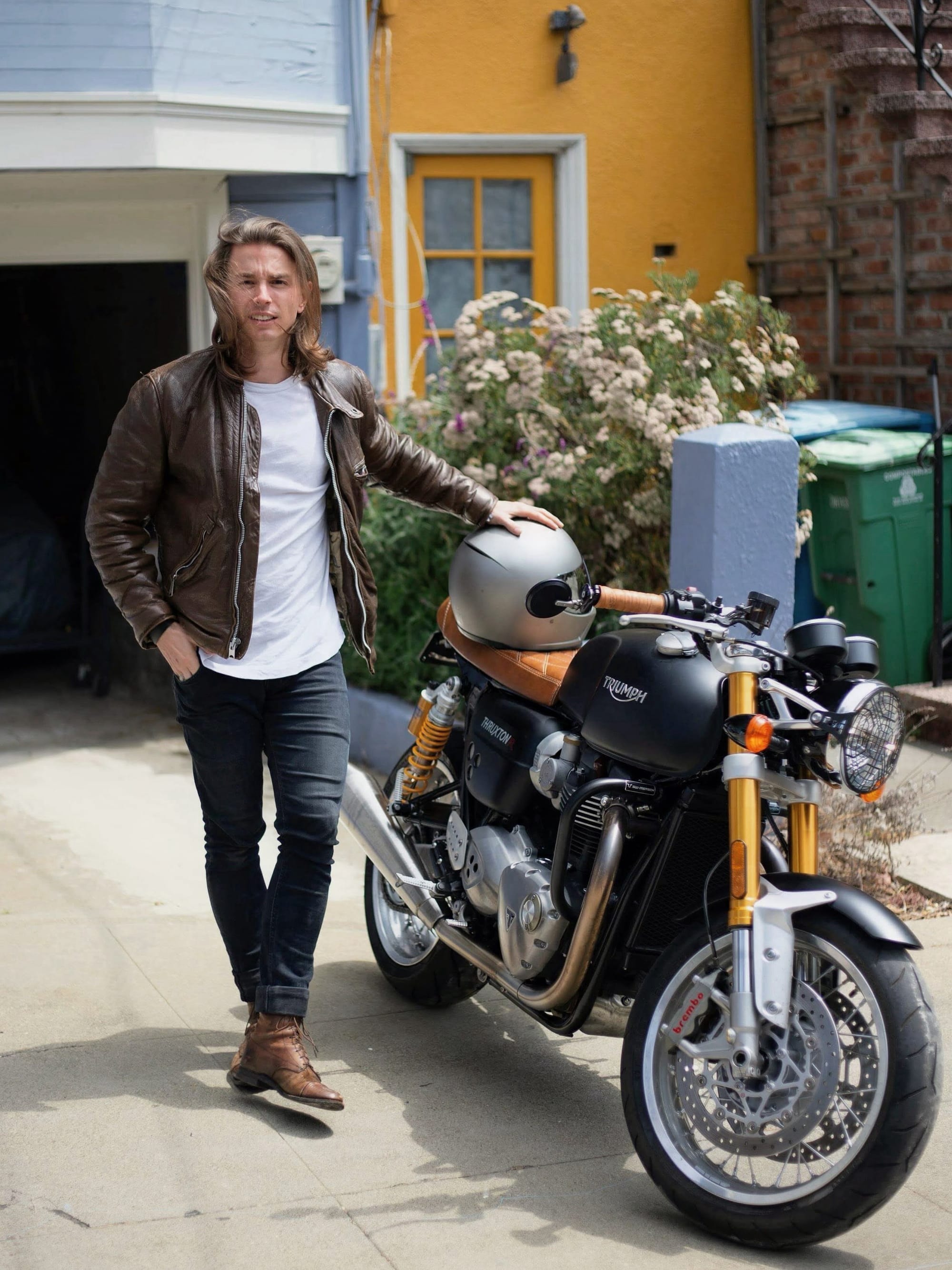 An earlier photograph of Grace standing beside the Triumph outside a house.