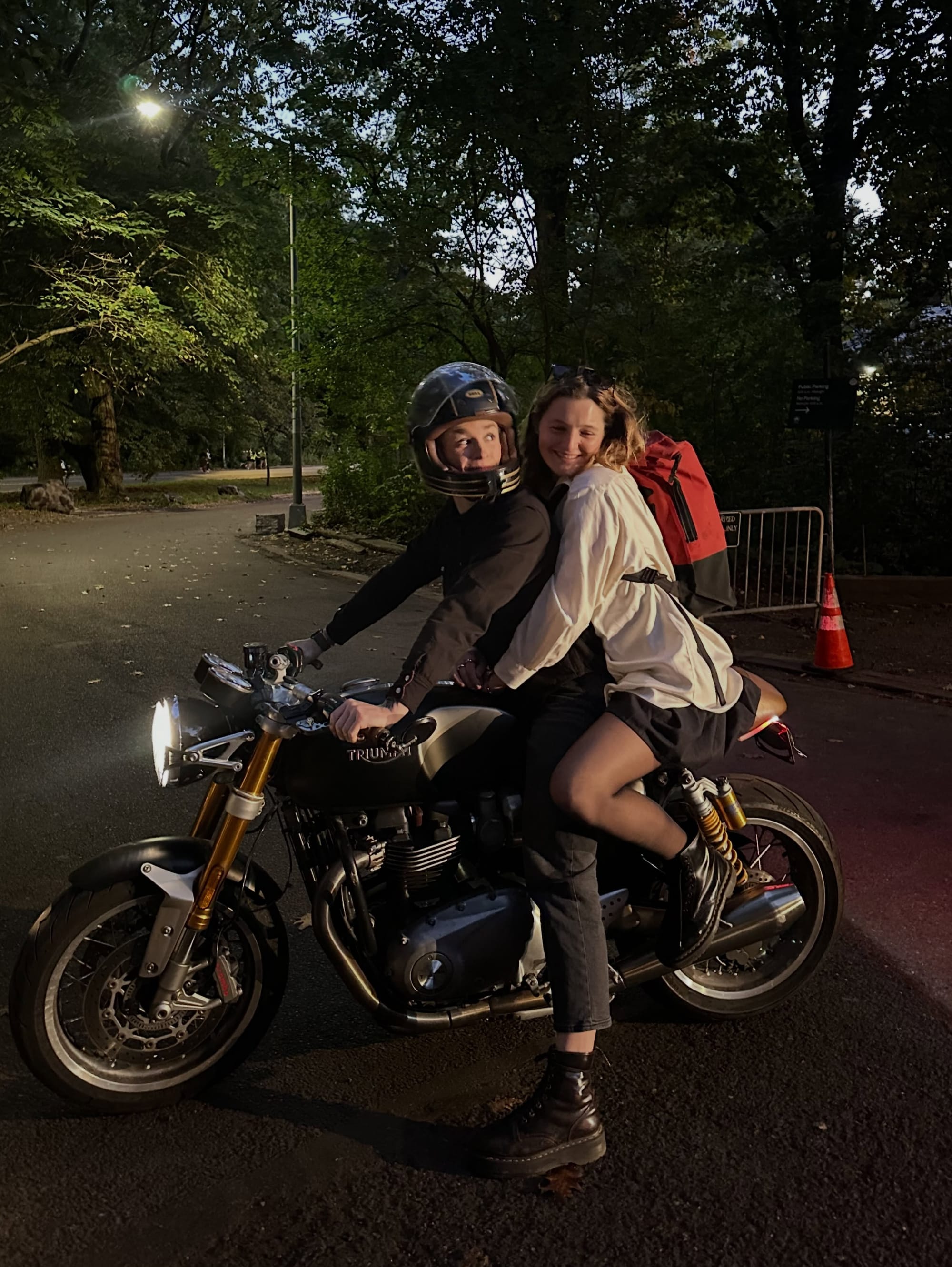 Grace and a passenger on the motorcycle at night.
